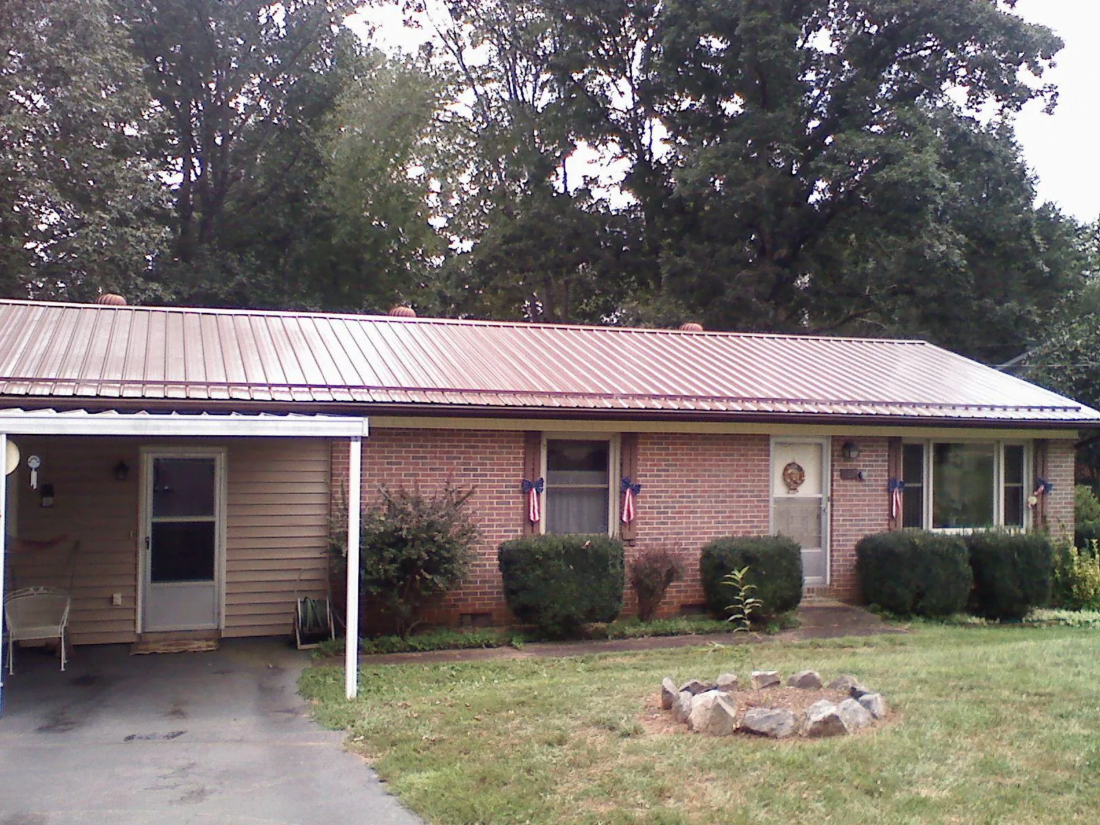 Bronze metal roof and carport on a brick ranch home — Roof Repair work by our crew in Guilford